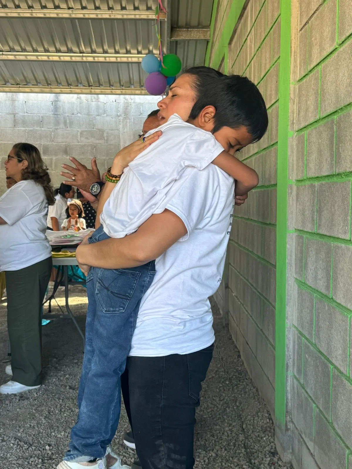 A volunteer worshipping while holding a child in Honduras