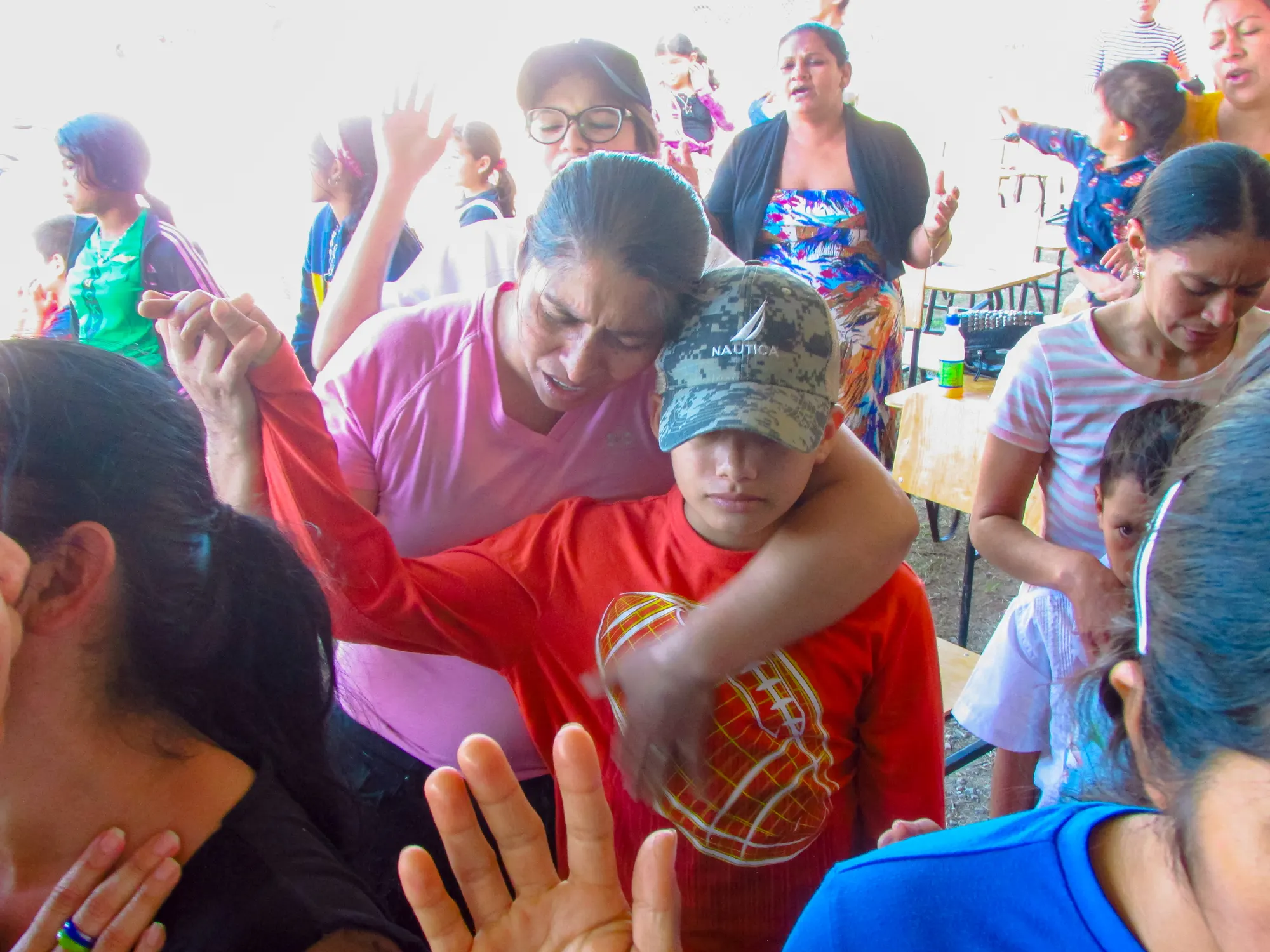 A mother praying over her son in Honduras